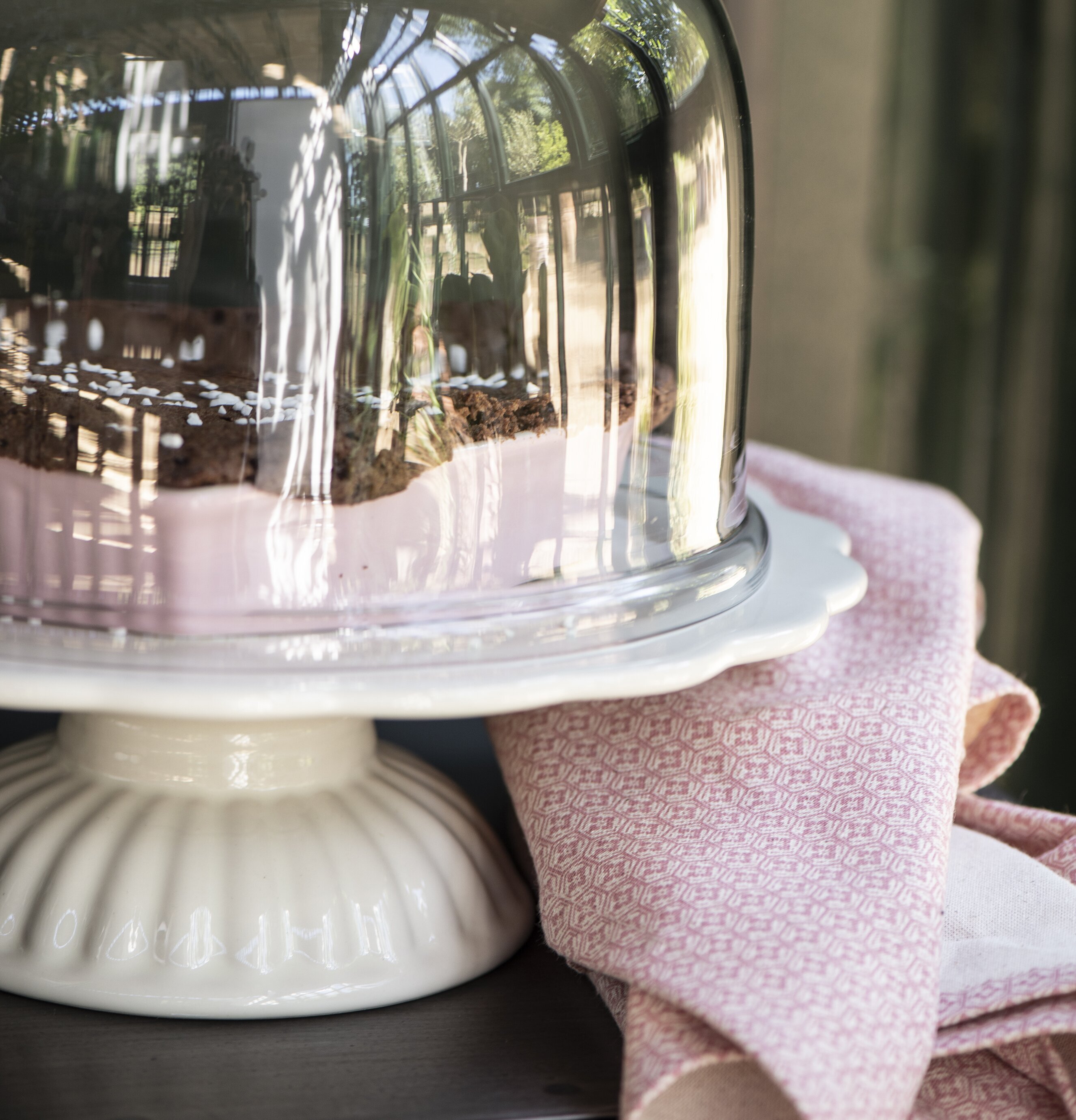 Bild av inbjudande arrangemang med tårtfat och glaskupa