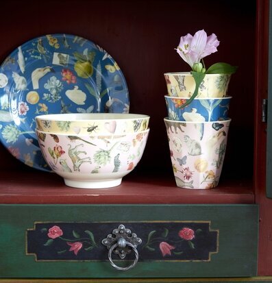 Bild av färgglatt porslin med naturmotiv i skåp