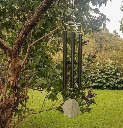 Foto av ett harmoniskt vindspel i grönskande trädgård