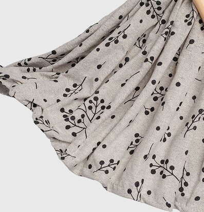 Bild av tygdesign med stiliserade grenar och prickar