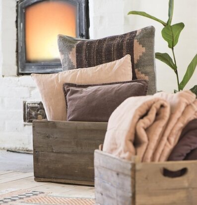 Bild av hemtrevlig inomhusmiljö med trälåda och kuddar