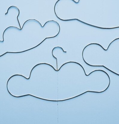 Bild av gyllene molnformade klädgalgar mot blå bakgrund