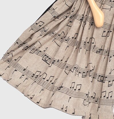 Bild av tyg med musiknoter och trädetalj i fokus