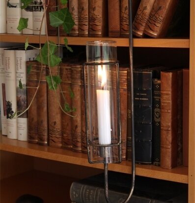 Bild av en harmonisk bokhylla med ljusstake och växter