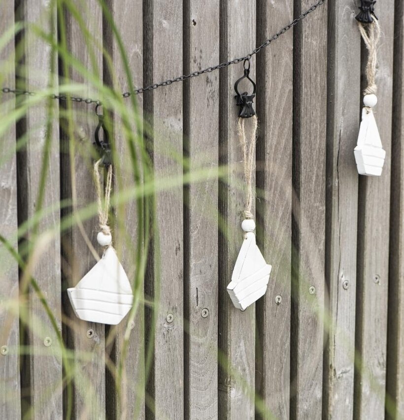 Kedja Clips från IB Laursen med vita träbåtar mot träpaneler