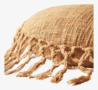 Bild av senapsgul kudde med texturerad yta och tofsar