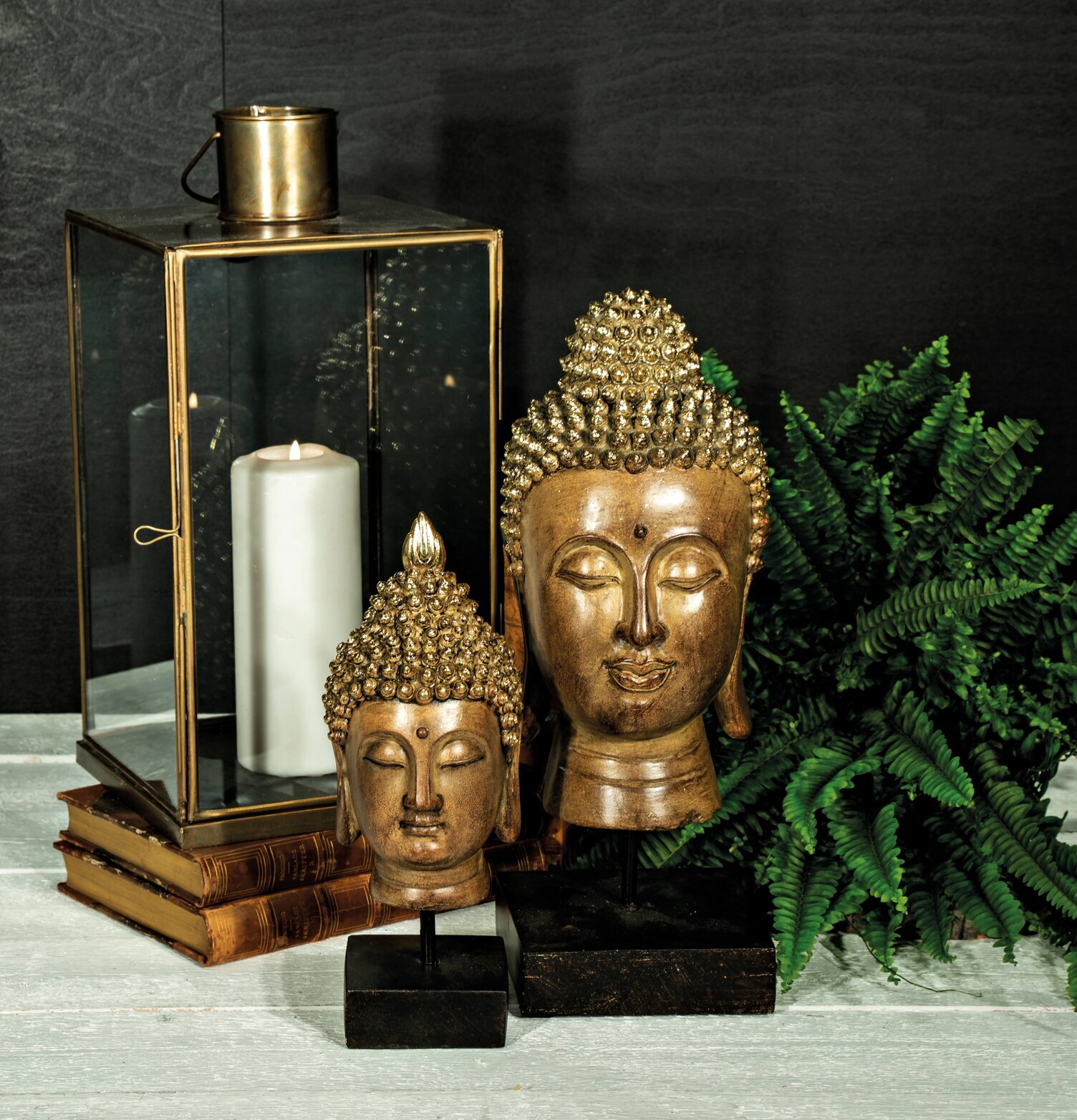 Yogish Buddha L från Trademan på bas bredvid lykta och växt