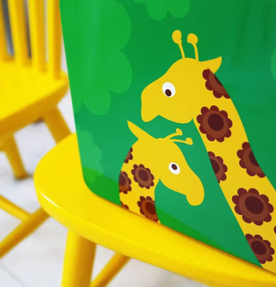 Bild av färgglad lunchbox med giraffmotiv och gul stol