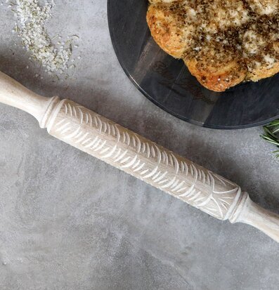 Bild av dekorativ kavel med intrikat mönster och bröd