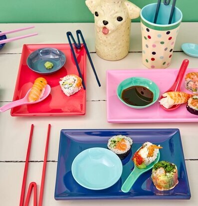 Bild av färgglatt dukat bord med sushi och tillbehör