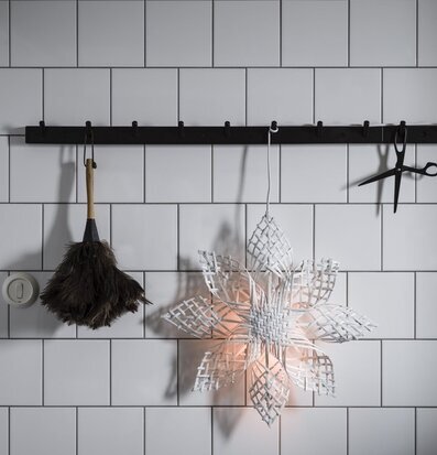 Foto av stilren vägg med vit stjärna och hatthylla