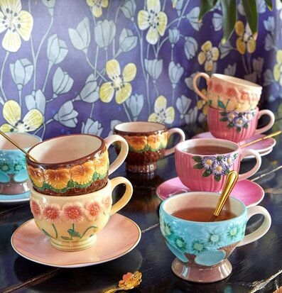 Bild av charmiga keramikmuggar med blommig design