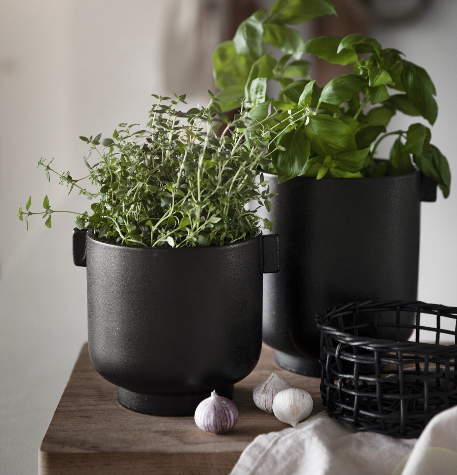 Bild på elegant inredning med svarta krukor och örter