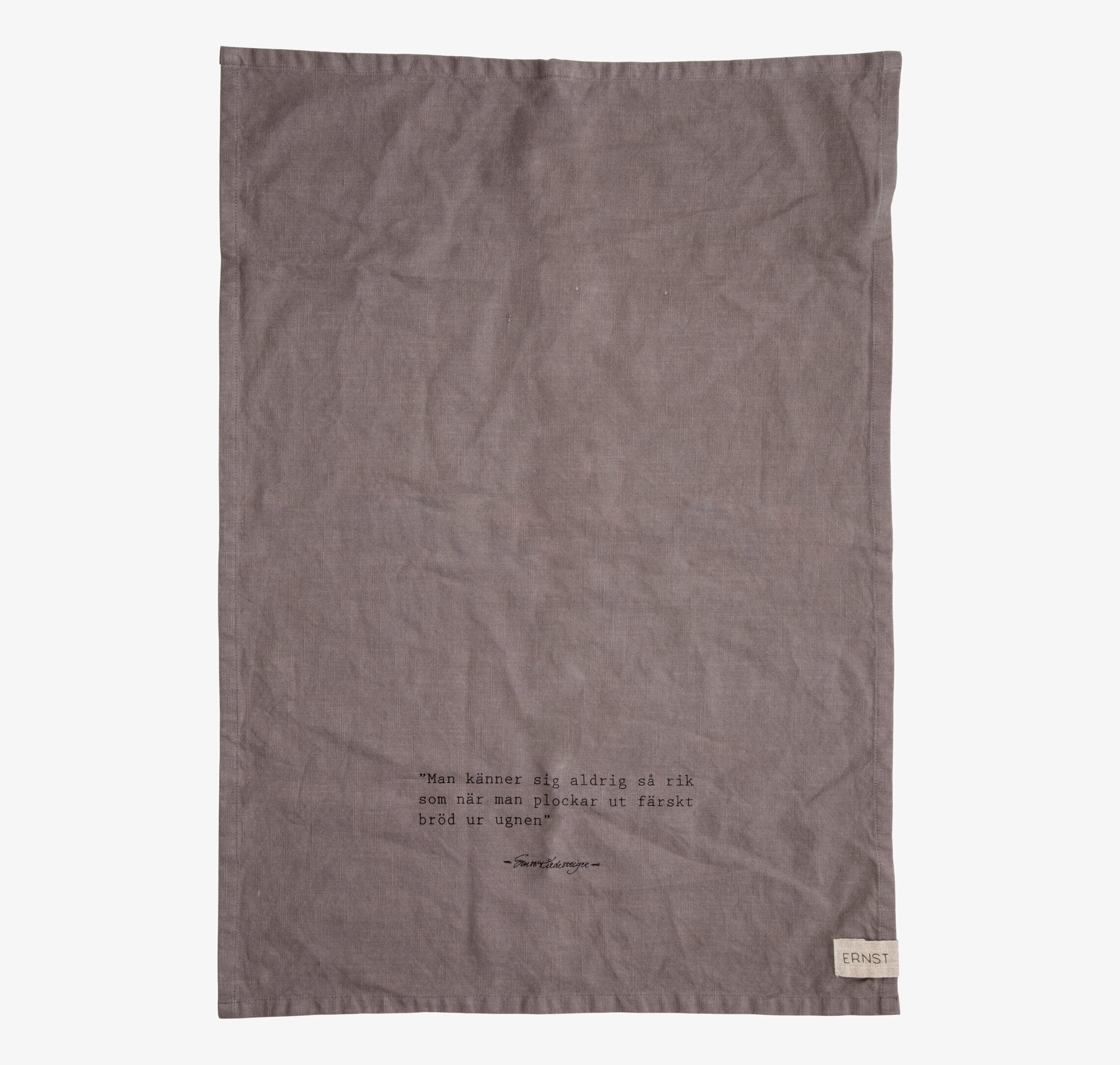 Foto av grå kökshandduk med citat och stilren design