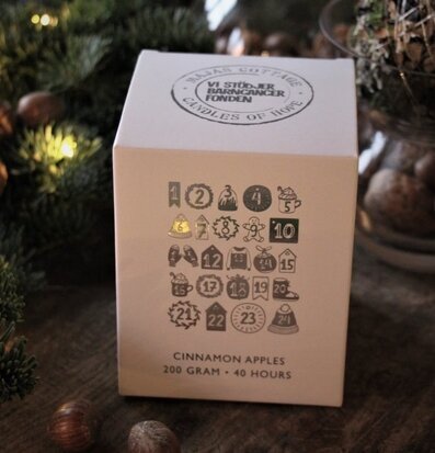 Bild av stämningsfull julscen med doftljus och grönt