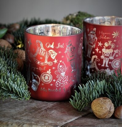 Bild av en ljuslykta med juldekorationer och valnötter