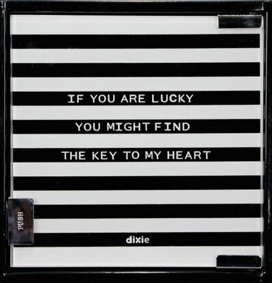 Bild av ett randigt nyckelskåp med text och tryckknapp