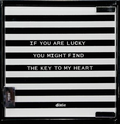 Bild av ett randigt nyckelskåp med text och tryckknapp