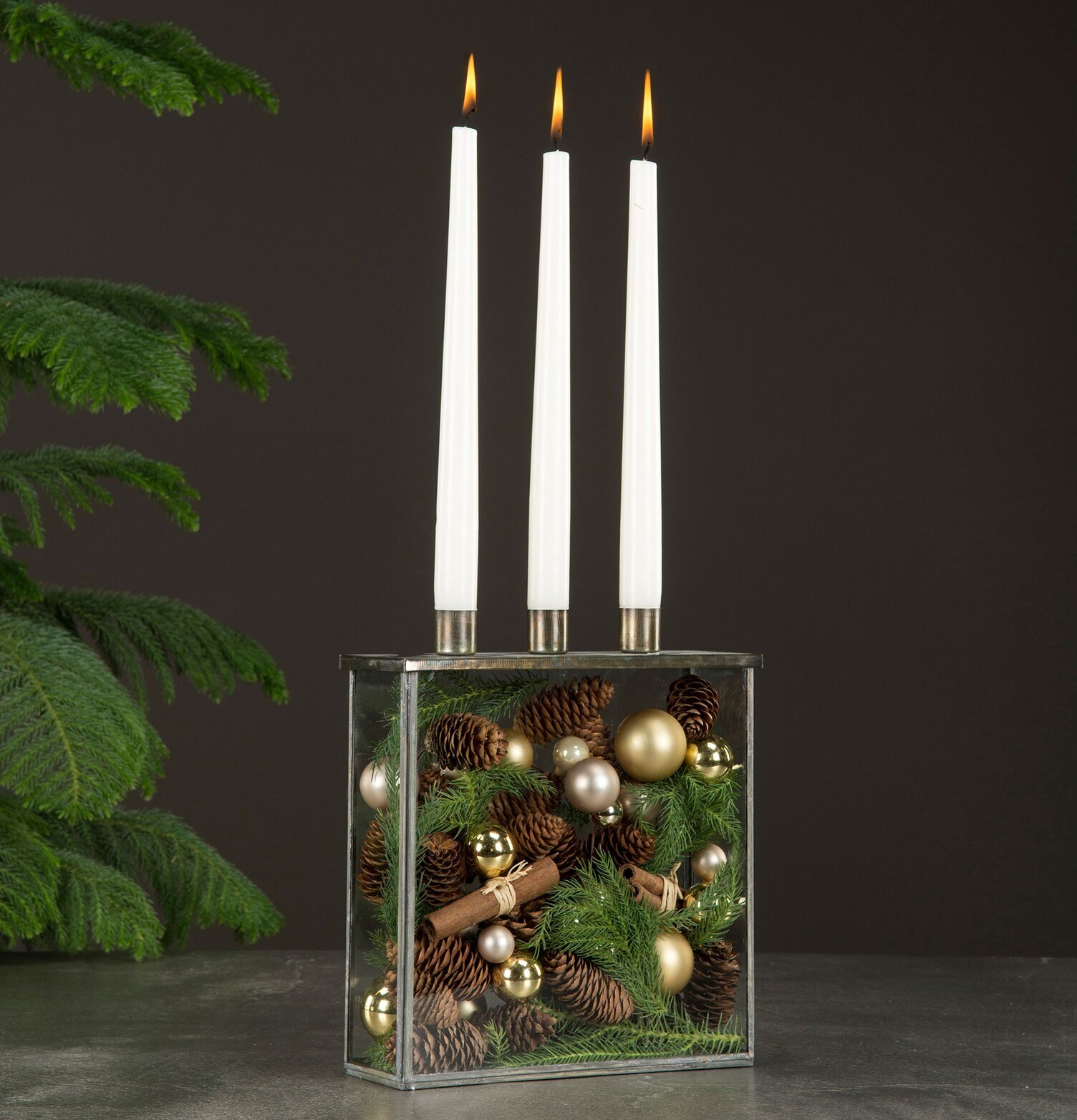 Bild av stilren glasbox med ljus och naturdekorationer