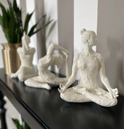 Bild av vita yogastatyetter i harmonisk inredning