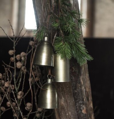 Bild av bjällror upphängda i naturinspirerad miljö