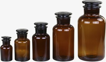 Bild av fem bärnstensfärgade glasflaskor i olika storlekar