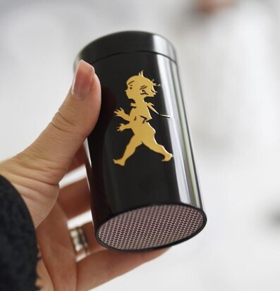 Bild av elegant tändsticksbehållare i svart och guld