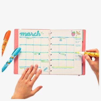 Foto av en kreativ kalender och färgglada pennor