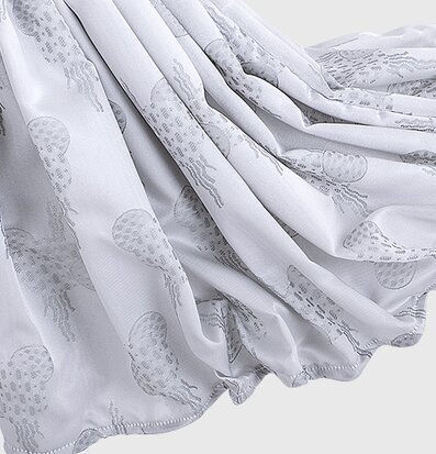 Bild av grått tyg med stiliserade maneter i mönster