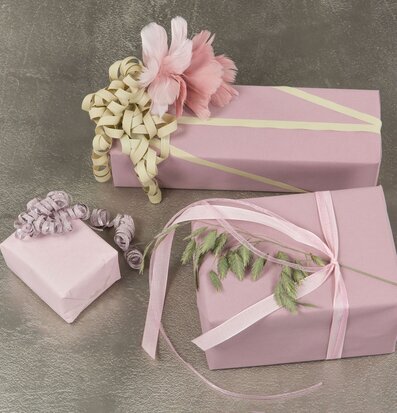 Bild av eleganta presenter i ljusrosa och krämiga toner