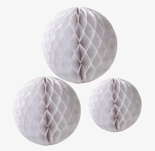 Bild av tre vita, runda dekorationer med bikakestruktur
