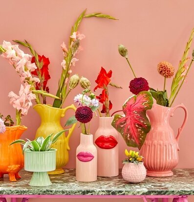 Bild av färgglada vaser och blomkrukor i inredning