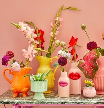 Bild av färgglada keramikkannor och vaser i inredning