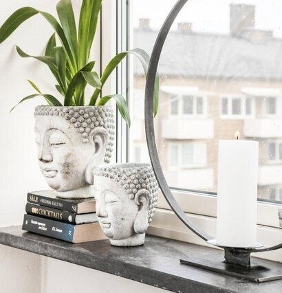 Kruka Buddha Large från Miljögården på fönsterbräda med växt