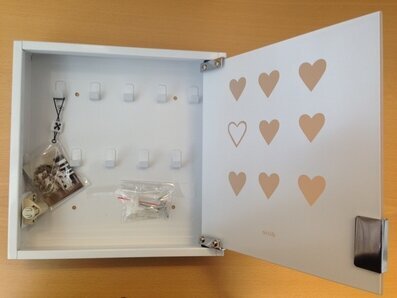 Bild av stilrent vitt nyckelskåp med hjärtdetaljer