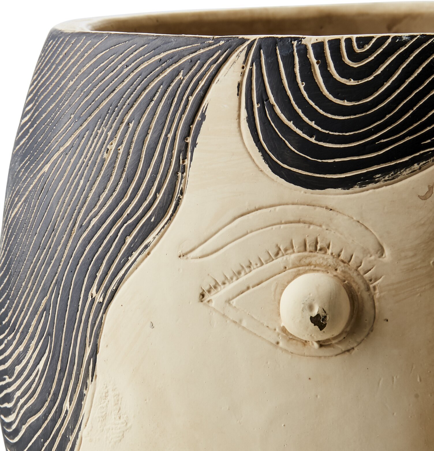 Foto av beige och svart kruka med skulpterat ansikte