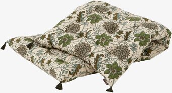 Bild av madrass med grönt blommönster och tofsar