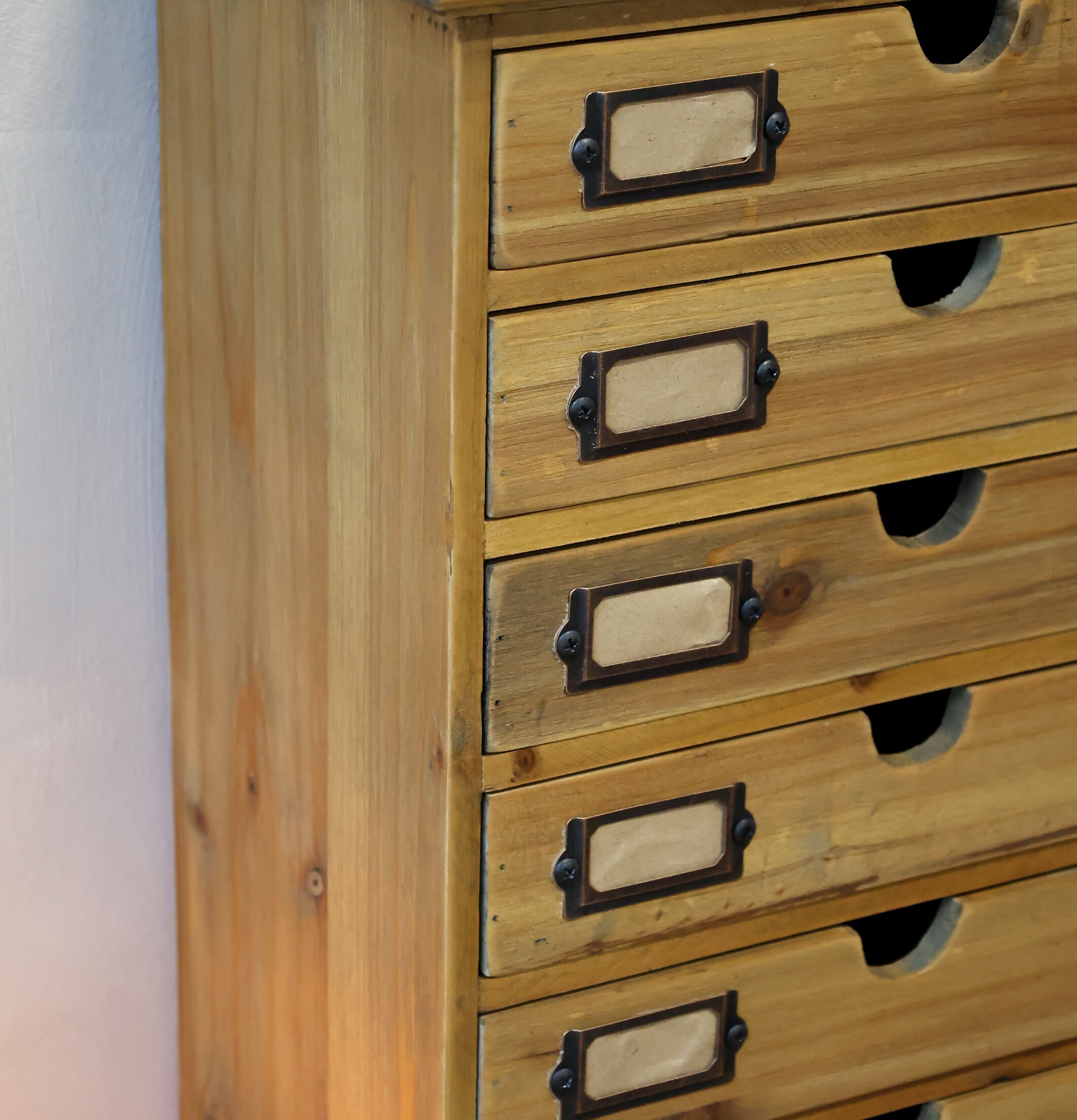 Bild av rustik byrå med sju lådor och metallhållare