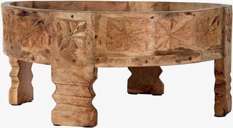 Bild av rund träbricka med unikt mönster och fötter