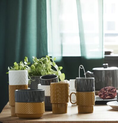 Bild av harmonisk köksscen med kaffemuggar och frukt