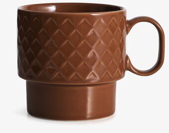 Foto av stilren temugg med rutmönster och terrakottafärg