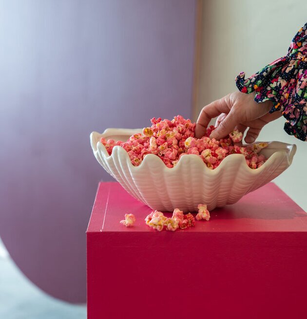 Bild av elegant scen med vit skål och färgglada popcorn