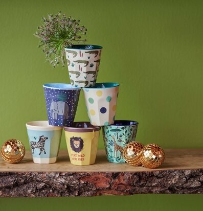 Foto av färgglada muggar i pyramid på rustik hylla