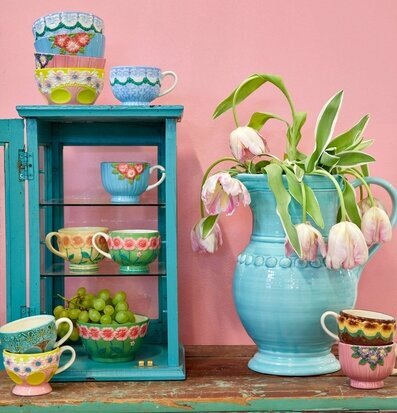 Bild av färgstarka keramikprodukter i livfull miljö