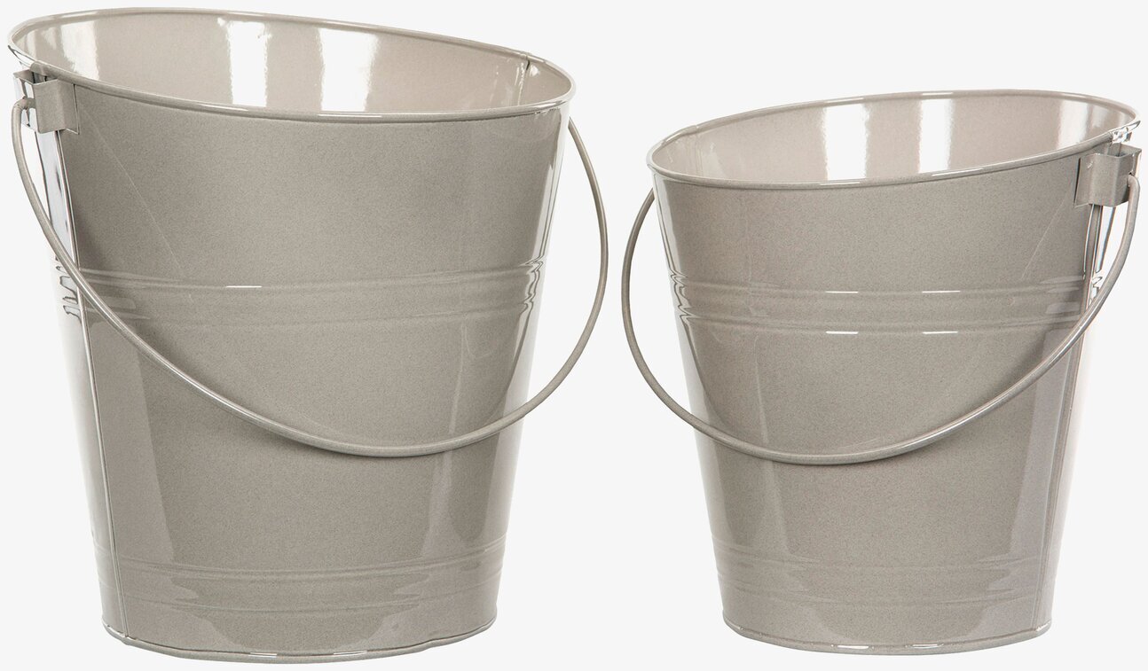 Bild av eleganta sandfärgade emaljhinkar i ljusreflektion