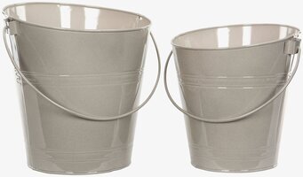 Bild av eleganta sandfärgade emaljhinkar i ljusreflektion