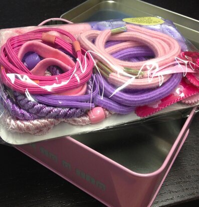 Bild av charmig plåtburk med färgglada håraccessoarer