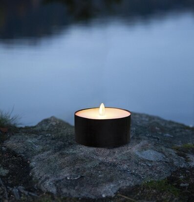 Bild av LED-ljus vid stenig vattenkant i naturen