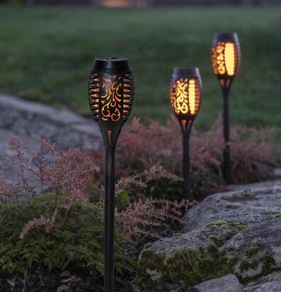 Foto av solcellsbelysning i stämningsfull trädgård