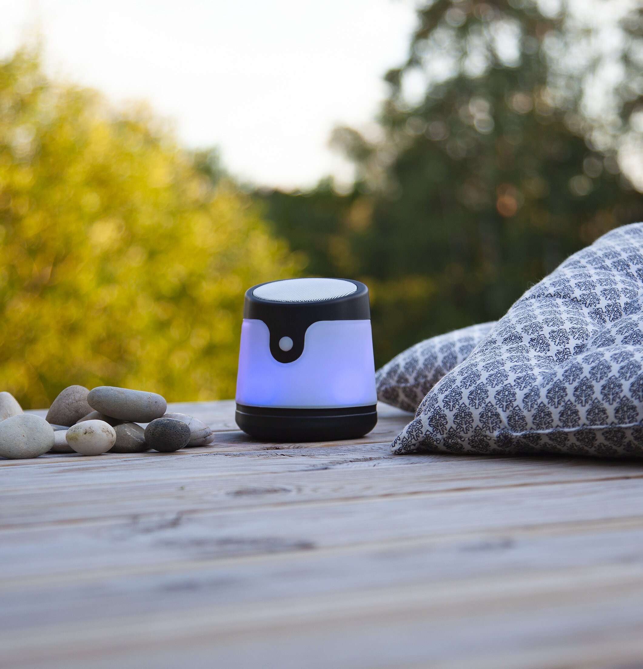 Bild av fridfull utomhusscen med modern högtalare